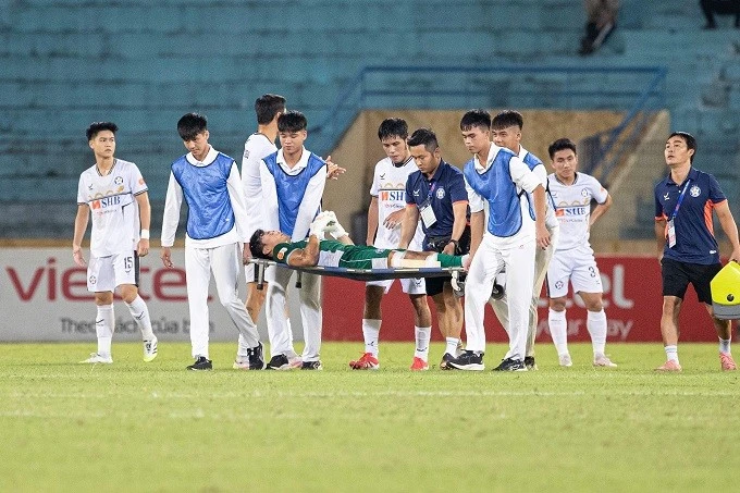Bùi Tiến Dũng rời sân bằng cáng.