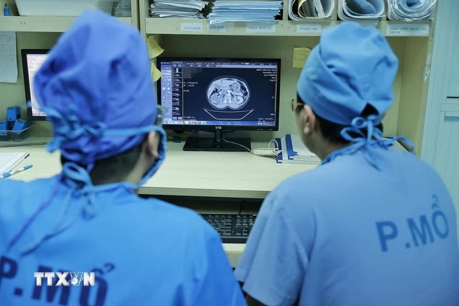 Các bác sỹ Bệnh viện Đại học Y Hà Nội xem hồ sơ bệnh án của bệnh nhân trước khi vào phẫu thuật.