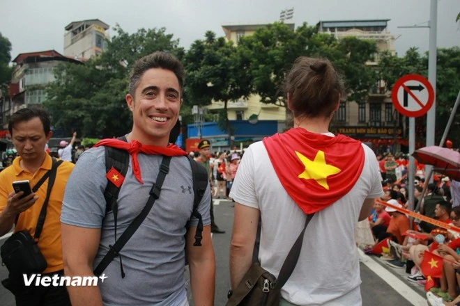 Du khách mua khăn quàng và kẹp tóc hình cờ Việt Nam hưởng ứng không khí kỷ niệm. (Ảnh: Minh Anh/Vietnam+)
