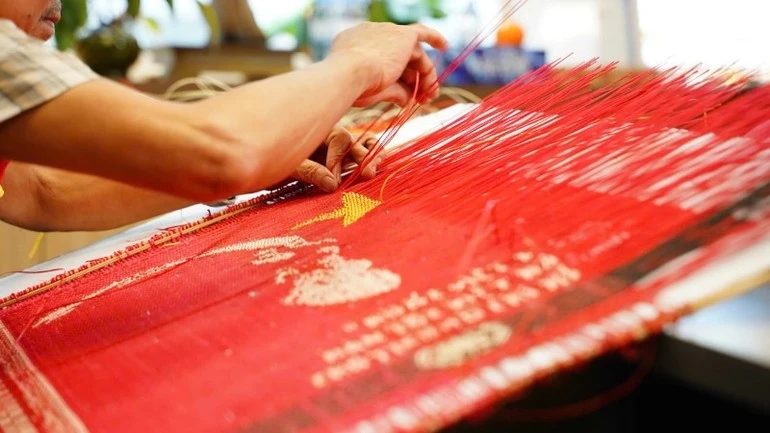 Bàn tay tài hoa của Nghệ nhân nhân dân Nguyễn Văn Trung đang thực hiện một công đoạn tác phẩm chân dung Bác Hồ.