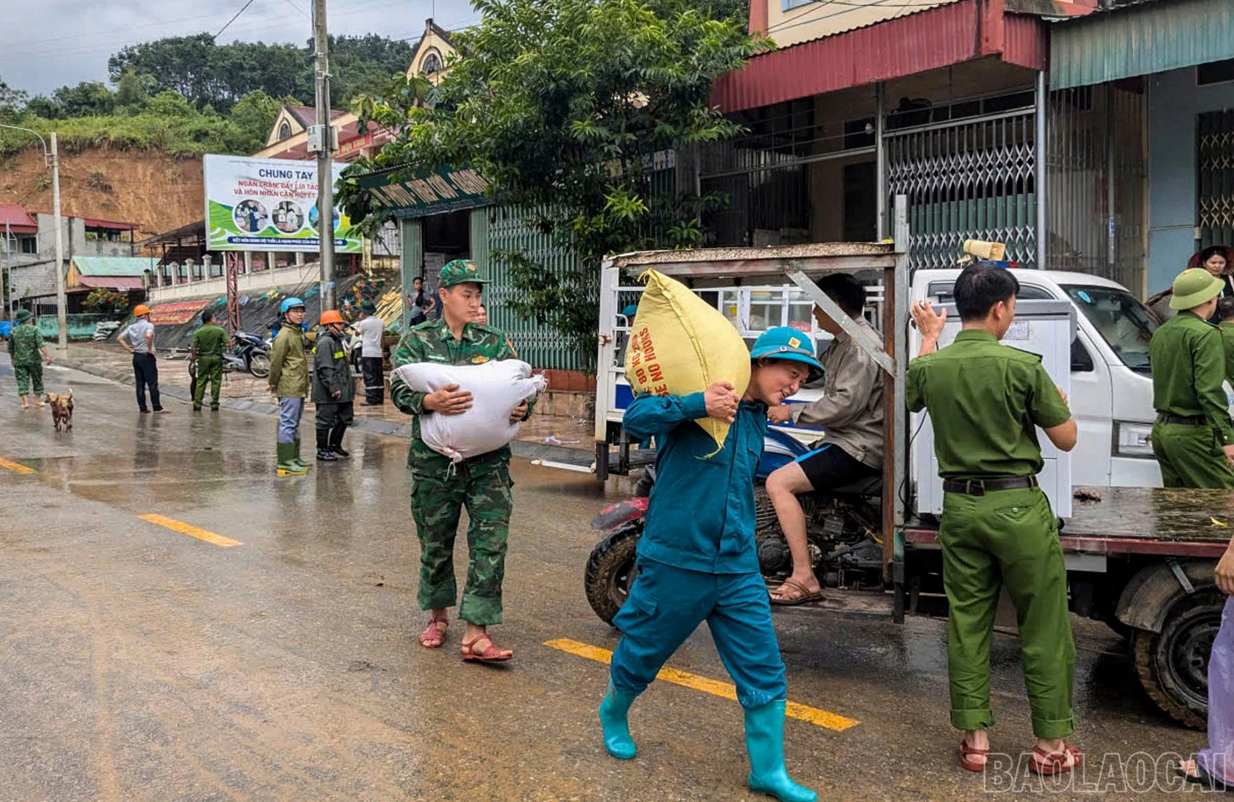 Các lực lượng giúp người dân tại khu vực sạt lở di chuyển tài sản đến nơi an toàn.