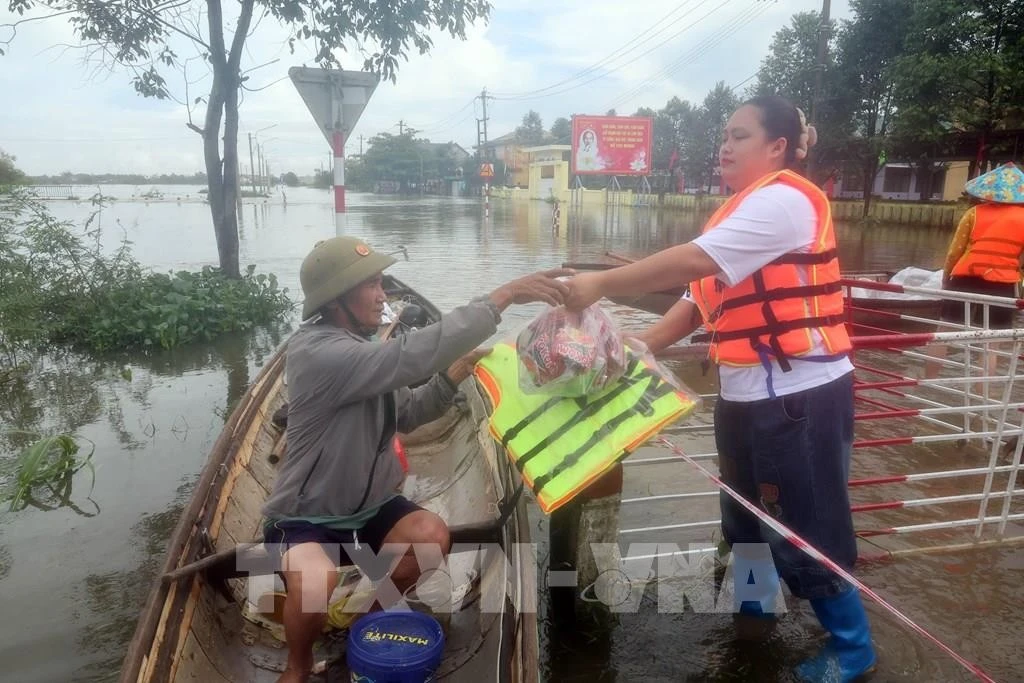 Đoàn tình nguyện trao tặng áo phao cho người dân vùng lũ.