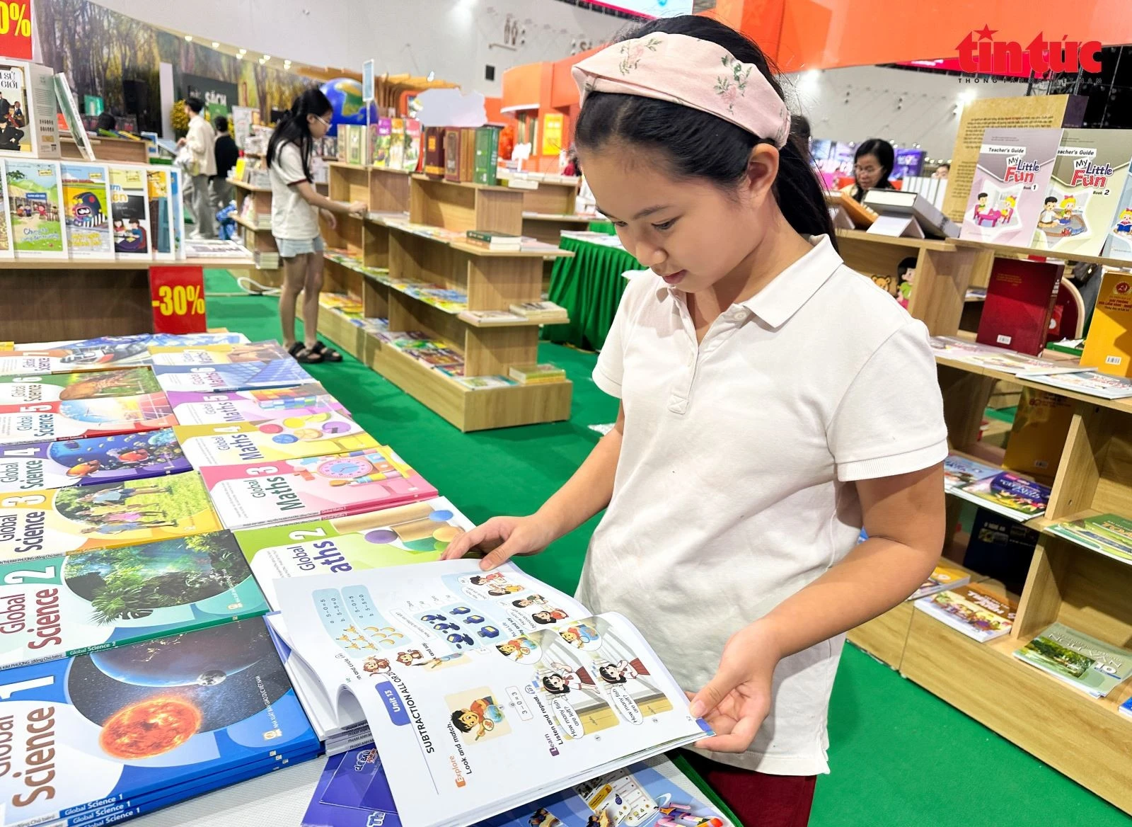 Em Bình An hạnh phúc khi được tham gia hội chợ, tìm đọc những cuốn sách yêu thích.