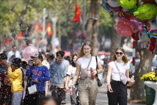Du khách quốc tế tham quan hồ Hoàn Kiếm dịp Tết Nguyên đán.