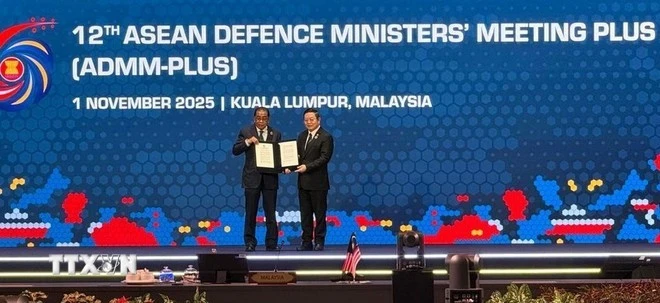 Bộ trưởng Quốc phòng Mohamed Khaled (trái) trao Tuyên bố chung của ADMM+ nhân dịp kỷ niệm 15 năm thành lập ADMM+ cho Tổng thư ký ASEAN Kao Kim Hourn (phải).