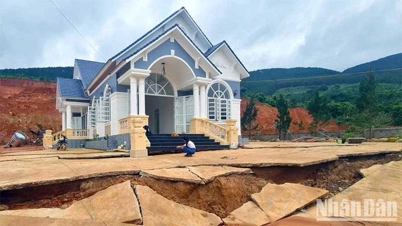 Sân trước ngôi nhà của ông Thắng bị nứt toác, phía sau nhà bị đất sạt trượt.